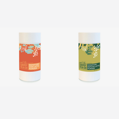 Two containers of Savoy latte powders, one labeled as Chai Latte Powder with orange and red tones, and the other as Matcha Latte Powder with green and white tones.