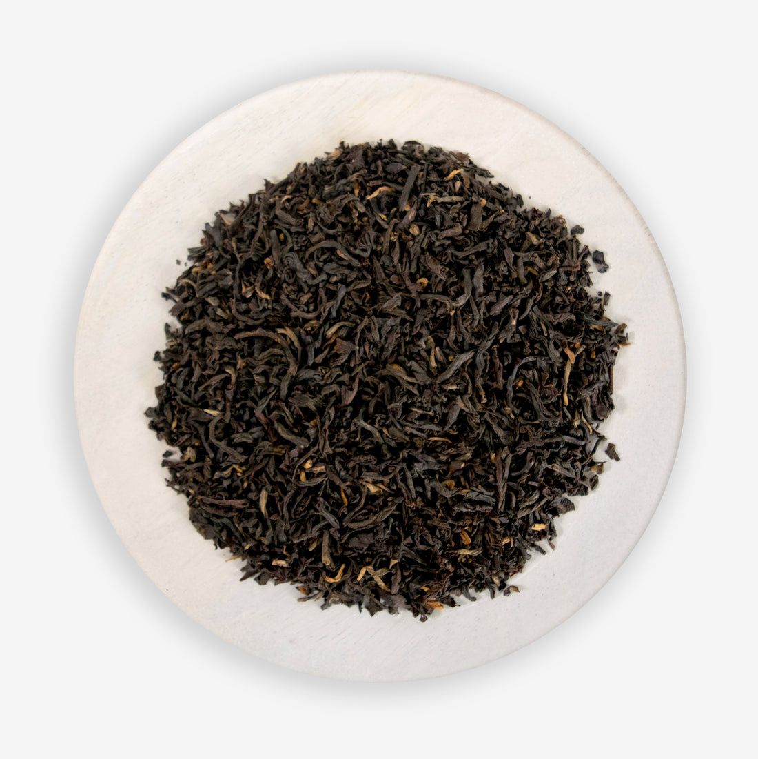 A pile of black tea leaves on a white background.