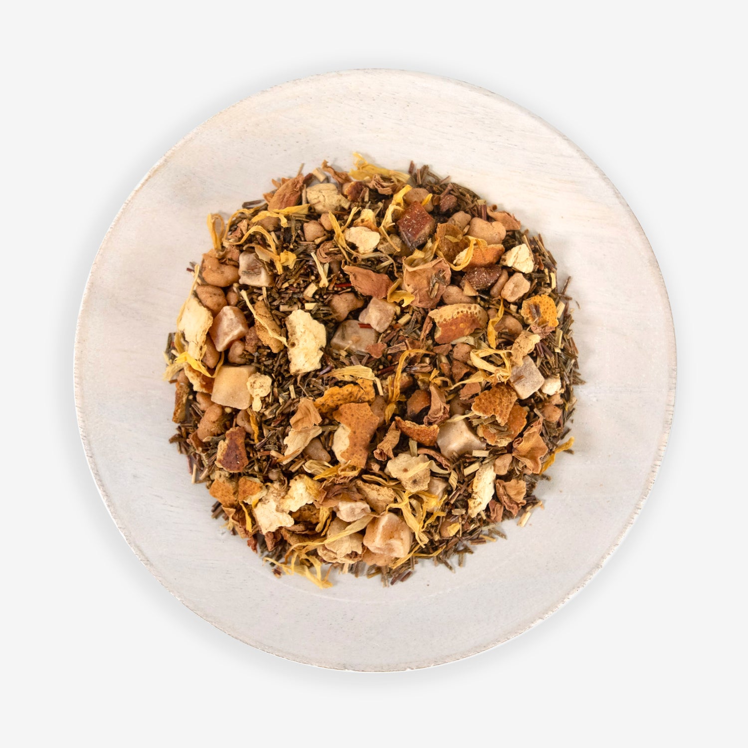 A top view of a plate containing Cape Paradise tea leaves which include a mix of dried fruits and petals.