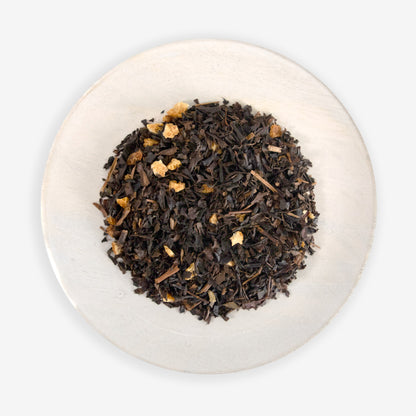 A top-down image of Citrus Oolong tea leaves mixed with pieces of orange peel, against a white background.