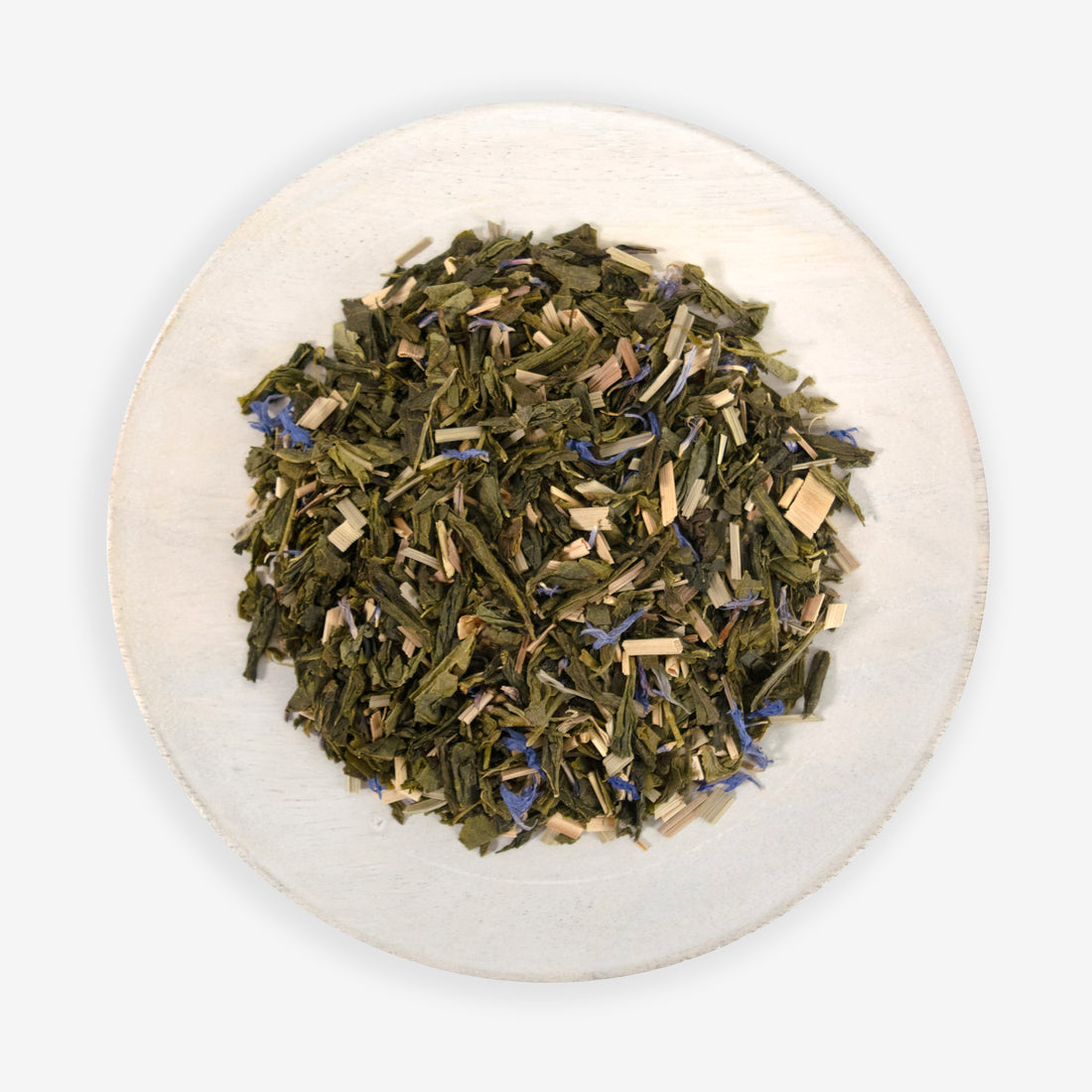A plate of dried tea leaves, herbs, and blue cornflower petals, which are ingredients for the &