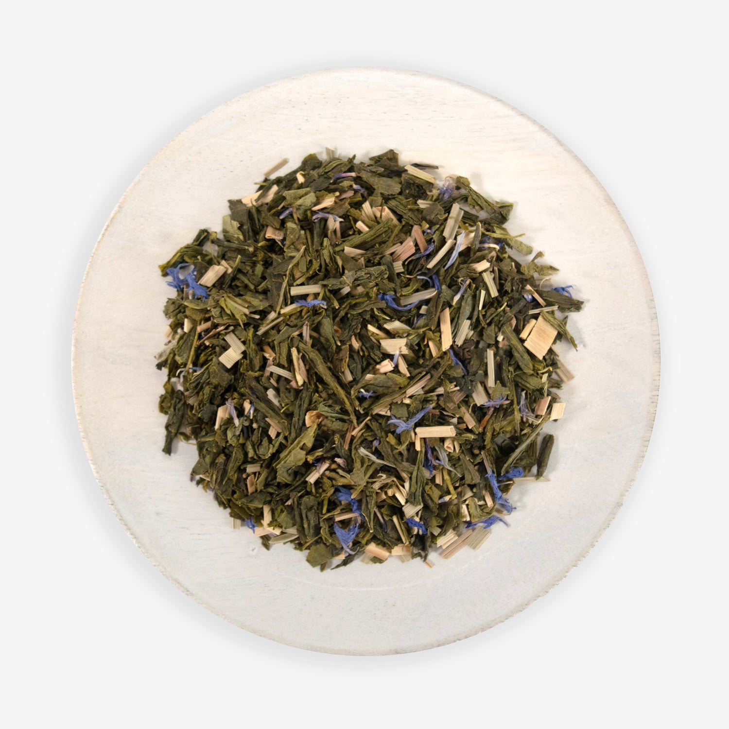 A plate of dried tea leaves, herbs, and blue cornflower petals, which are ingredients for the &