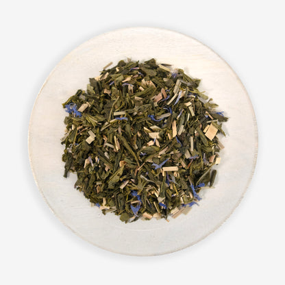 A plate of dried tea leaves, herbs, and blue cornflower petals, which are ingredients for the &