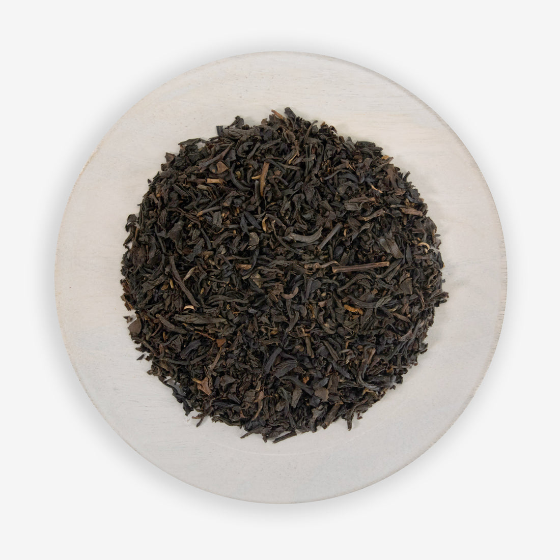 A plate of fine black tea leaves mixed with pieces of all-natural vanilla flavor.