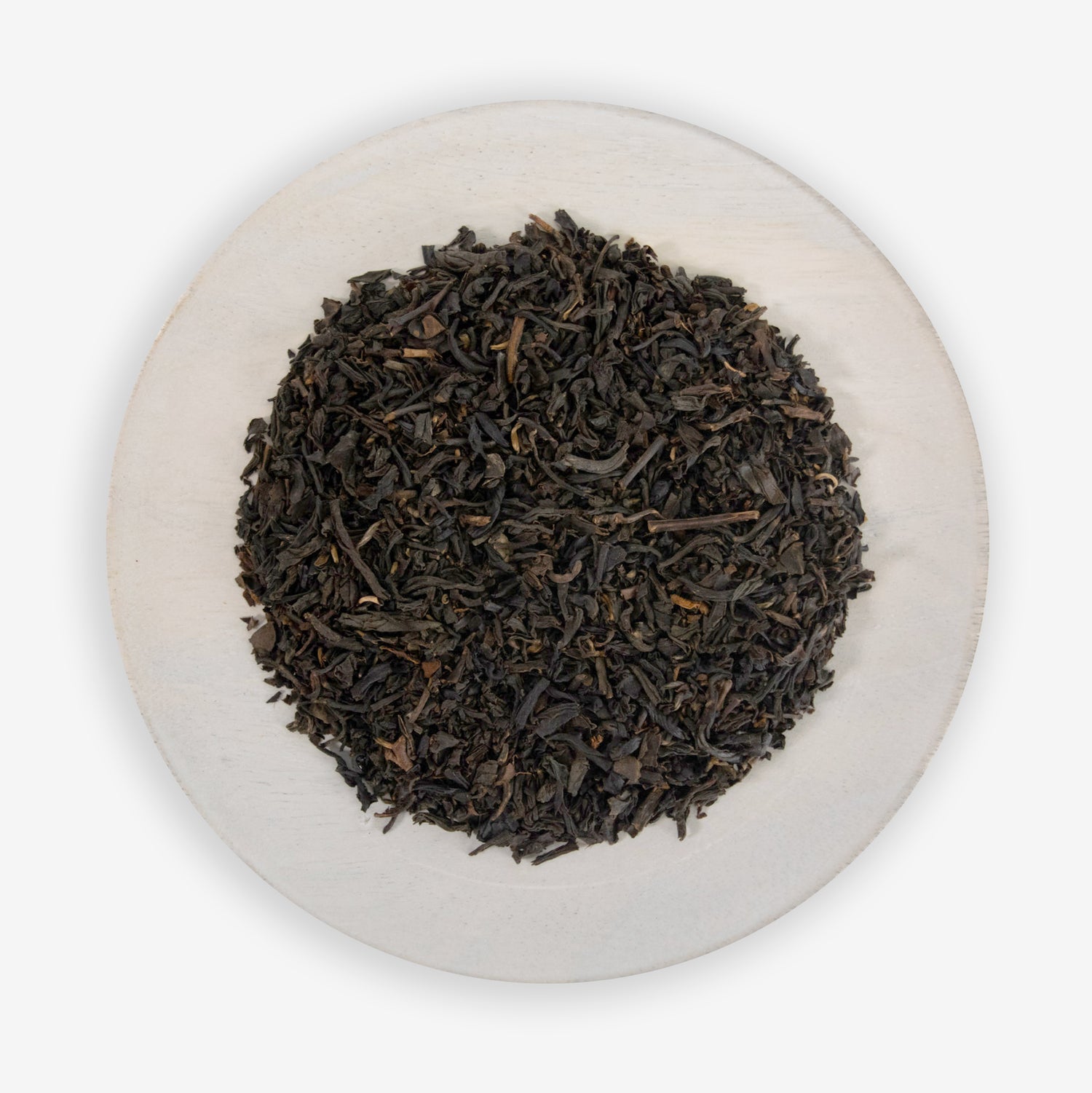 A plate of fine black tea leaves mixed with pieces of all-natural vanilla flavor.