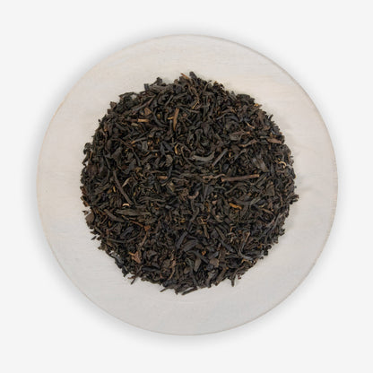 A plate of fine black tea leaves mixed with pieces of all-natural vanilla flavor.